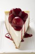 A piece of cheesecake with cherry sauce