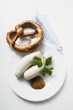 Two Weisswurst (white sausages) with pretzel and mustard
