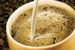 Pouring milk into a cup of coffee