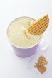 A tub of vanilla ice cream with wafer