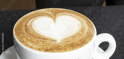 Photo: A cup of cappuccino with milk foam decorated with heart A cup of cappuccino with milk foam decorated with heart