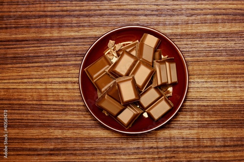 Photo: Pieces of chocolate on brown plate Pieces of chocolate on brown plate
