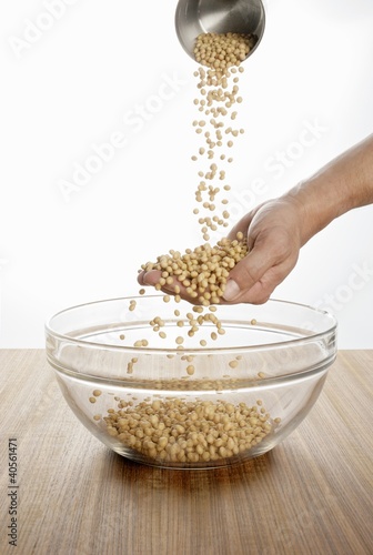Foto: Someone pouring soya beans over their hand into a glass bowl Someone pouring soya beans over their hand into a glass bowl