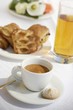A cup of espresso, apple juice and pastries