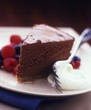 Foto: A piece of chocolate cake with whipped cream and berries A piece of chocolate cake with whipped cream and berries
