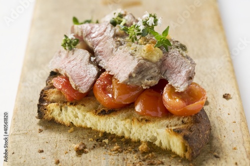 Photo: Beef steak with cherry tomatoes on toasted bread Beef steak with cherry tomatoes on toasted bread
