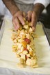 Making fruit strudel: spreading filling on strudel pastry