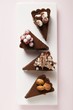 Four pieces of chocolate tart with different decorations