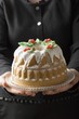 Woman serving iced walnut gugelhupf