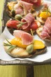 Crostini with raw ham, peppers and giant capers