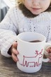 Small girl drinking large mug of cocoa
