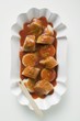 Sausage with ketchup & curry powder in paper dish (overhead)