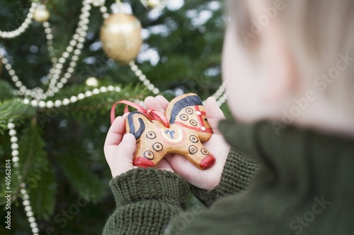 Photo: Child holding gingerbread horse (tree ornament) Child holding gingerbread horse (tree ornament)