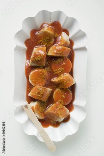 Foto: Sausage with ketchup & curry powder in paper dish (overhead) Sausage with ketchup & curry powder in paper dish (overhead)