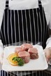 Person holding tray of pork medallions
