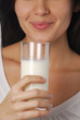 Joven mujer bebiendo un vaso de leche fresca.