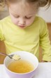 Small girl eating noodle soup