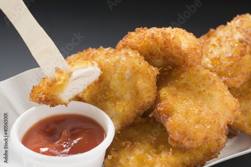Photo: Chicken nuggets with ketchup in paper dish Chicken nuggets with ketchup in paper dish