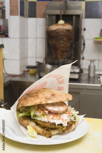 Photo: Pita bread with falafel on counter in front of döner grill Pita bread with falafel on counter in front of döner grill