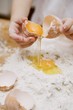 Making pasta dough: a child breaking an egg