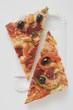 Slice of pepperoni pizza with peppers and olives (halved)