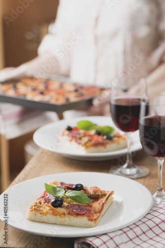Photo: Slices of pepperoni pizza with olives, glasses of red wine Slices of pepperoni pizza with olives, glasses of red wine