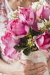 Woman holding vase of summer flowers