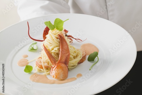 Photo: Waiter serving linguine with lobster Waiter serving linguine with lobster