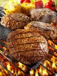 Burgers on barbecue rack and on spatula