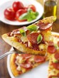 Slice of pepperoni pizza with basil on server