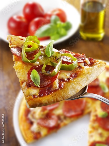 Foto: Slice of pepperoni pizza with chilli rings on server Slice of pepperoni pizza with chilli rings on server