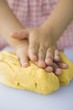 Child's hands kneading dough