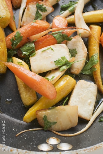 Foto: Fried root vegetables with parsley in frying pan Fried root vegetables with parsley in frying pan