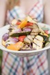 Foto: Woman holding a plate of grilled vegetables Woman holding a plate of grilled vegetables