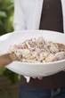 Foto: Person holding a dish of potato salad Person holding a dish of potato salad