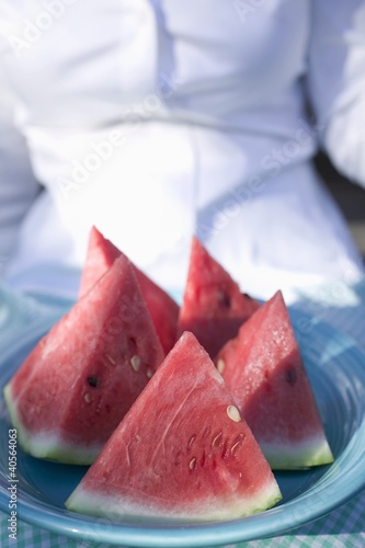 Foto: Woman holding a plate of watermelon wedges Woman holding a plate of watermelon wedges