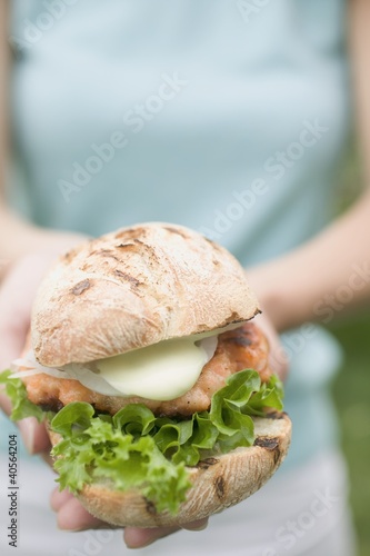 Foto: Woman holding chicken burger Woman holding chicken burger