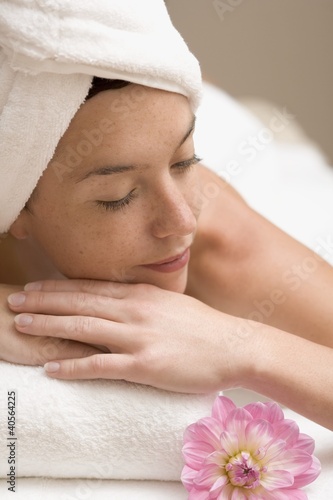 Foto: Woman lying down, resting on white towel Woman lying down, resting on white towel