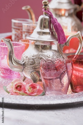 Foto: Silver teapot, glasses, roses and windlights on tray Silver teapot, glasses, roses and windlights on tray