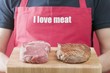Man holding raw and grilled beef steaks on chopping board