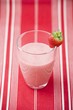 Strawberry milk in glass with fresh strawberry on rim