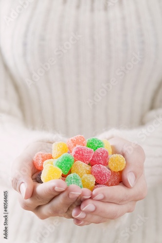Photo: Hands holding coloured sugar-coated jelly sweets Hands holding coloured sugar-coated jelly sweets