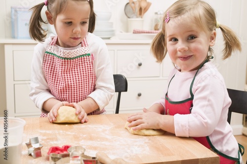 Photo: Two small girls kneading dough Two small girls kneading dough