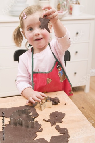 Photo: Small girl cutting out chocolate biscuits Small girl cutting out chocolate biscuits