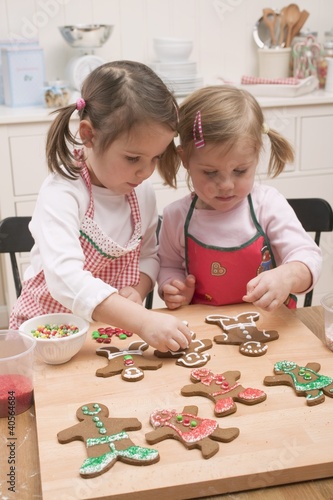 Photo: Two small girls decorating gingerbread men Two small girls decorating gingerbread men