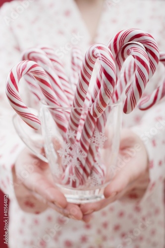 Photo: Woman holding glass of candy canes Woman holding glass of candy canes