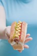 Photo: Woman holding hot dog with mustard, relish and ketchup Woman holding hot dog with mustard, relish and ketchup