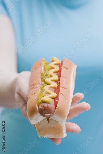 Photo: Woman holding hot dog with mustard, relish and ketchup Woman holding hot dog with mustard, relish and ketchup