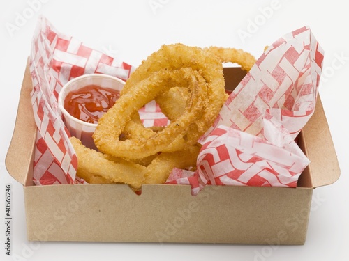 Foto: Deep-fried onion rings with ketchup in a cardboard box Deep-fried onion rings with ketchup in a cardboard box