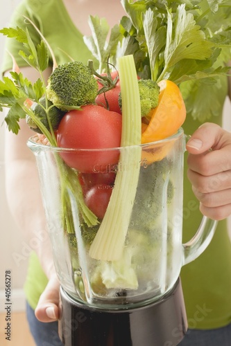 Photo: Woman holding fresh vegetables in liquidiser Woman holding fresh vegetables in liquidiser